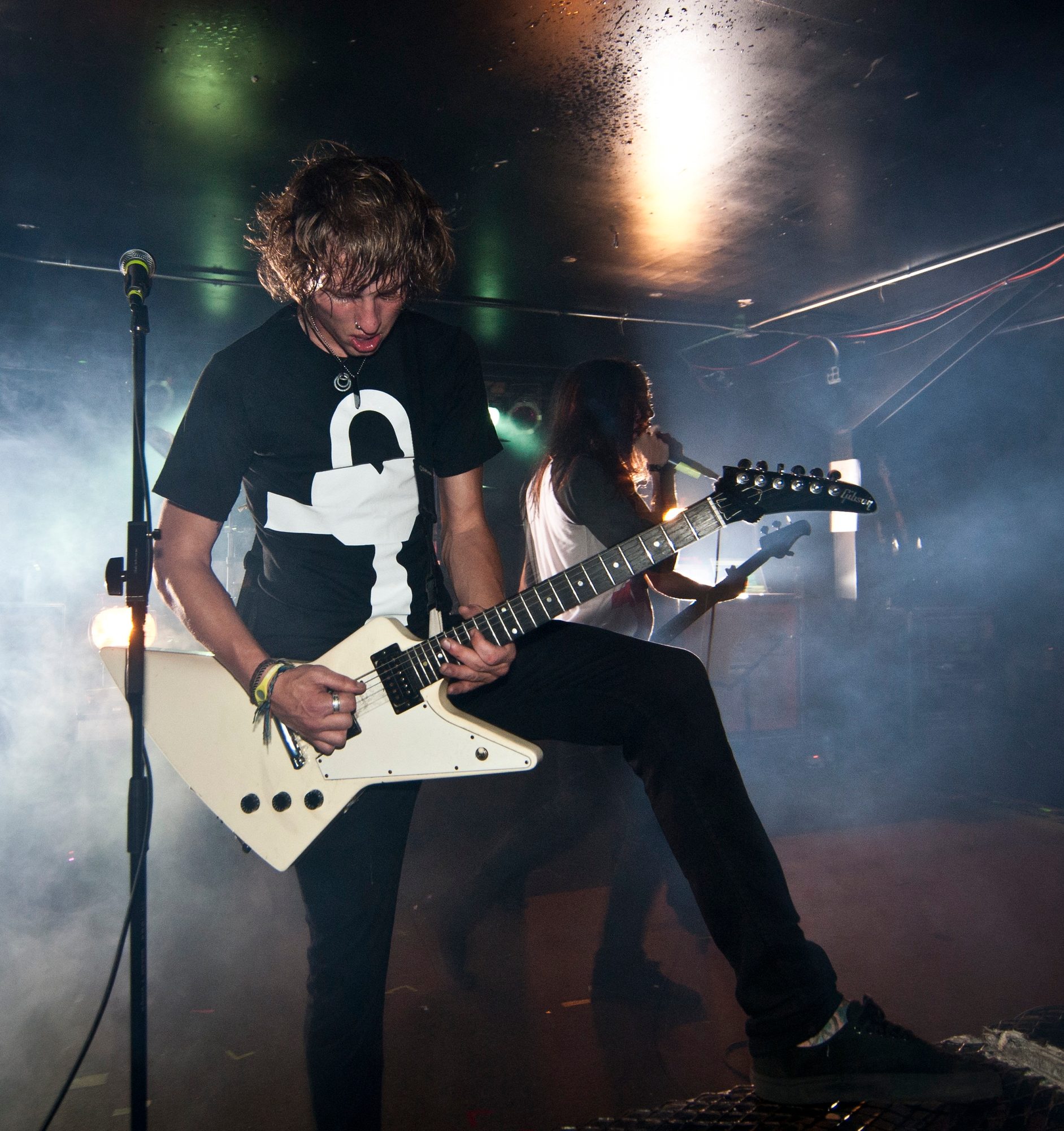 A musician wearing an RA Apparel shirt performing on stage