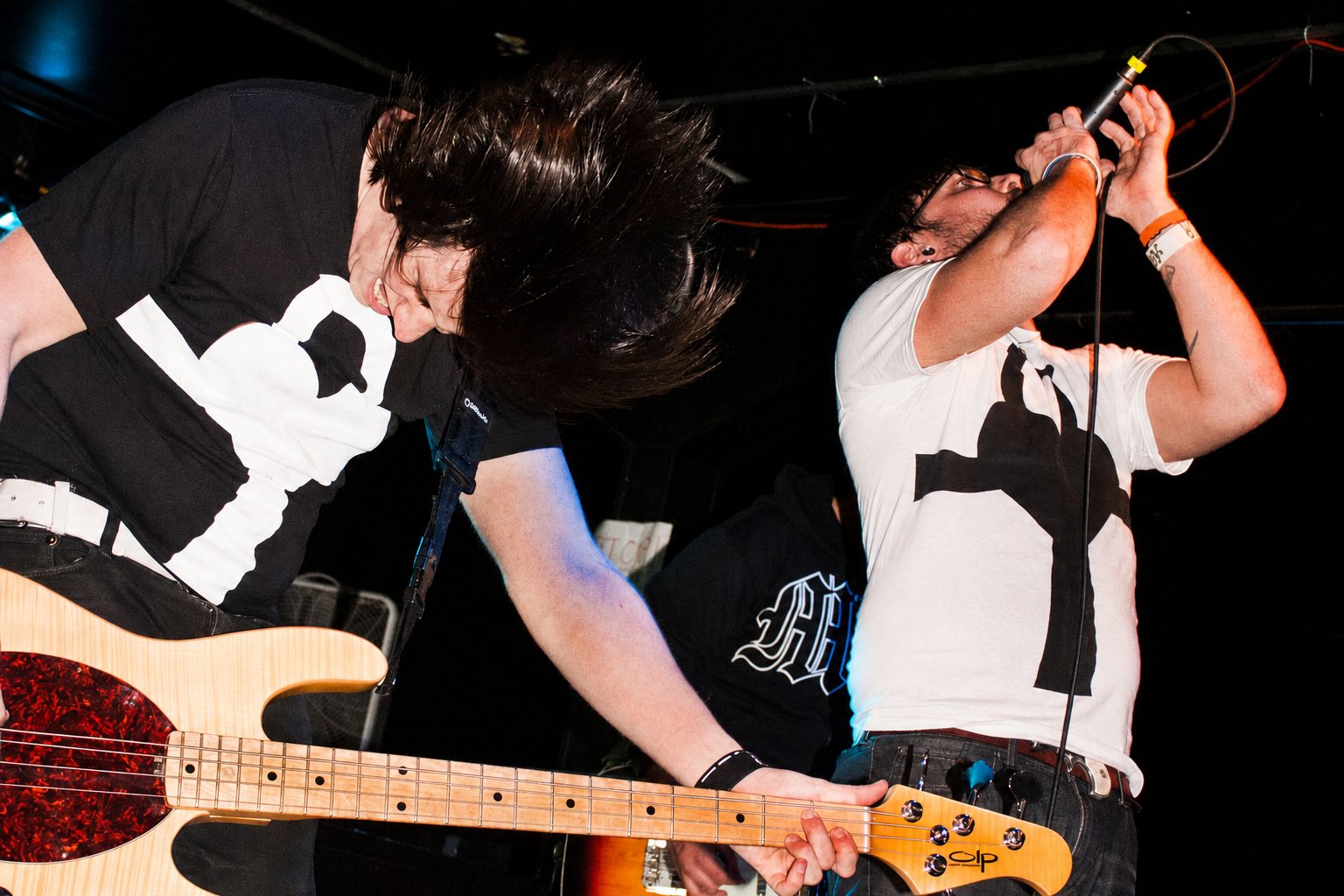 Musicians wearing RA Apparel shirts performing on stage