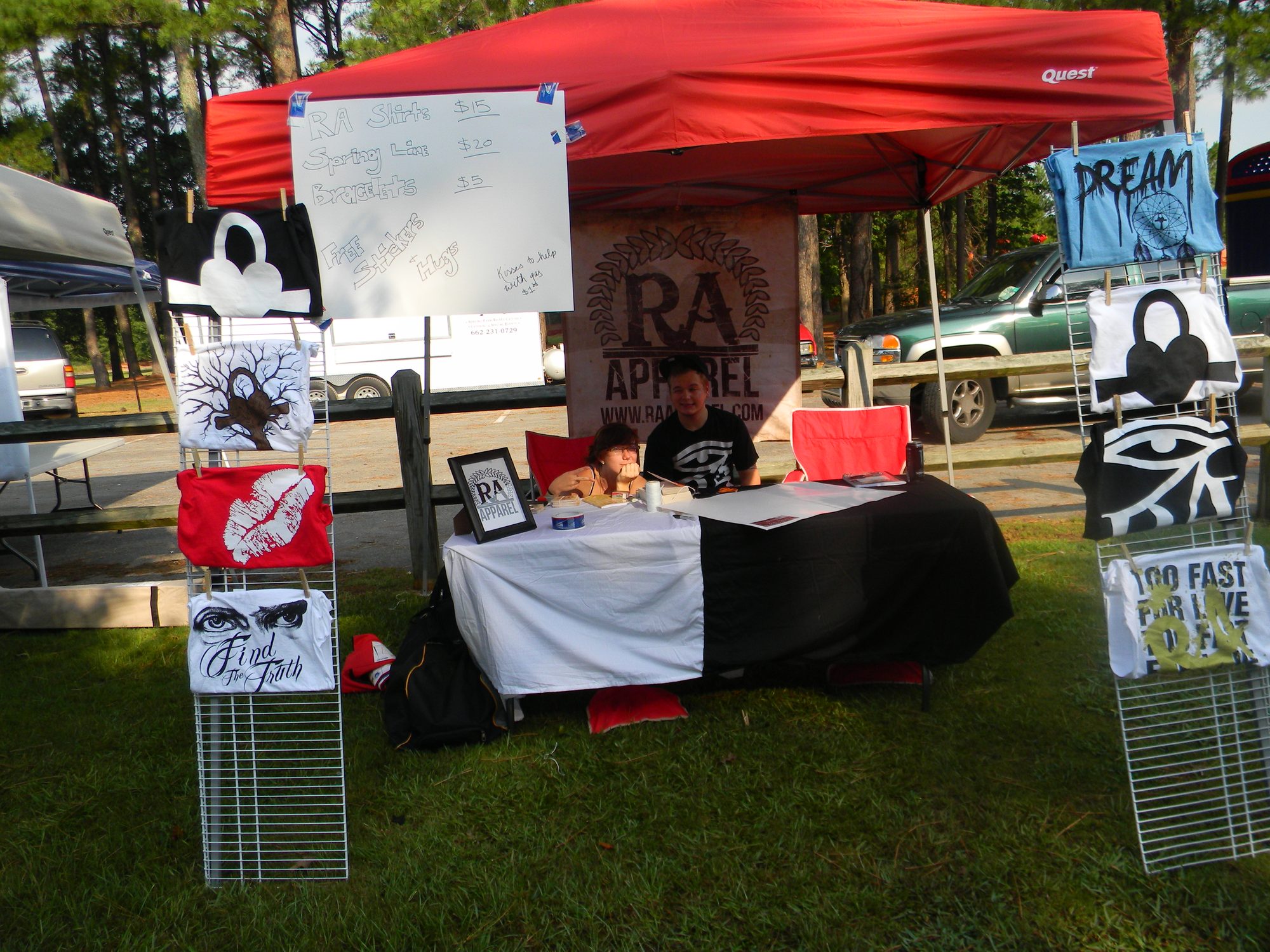 RA Apparel vending booth at a local show, with shirts and a price list on display